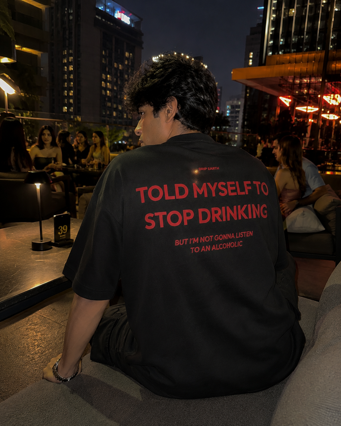Black Drip Earth oversized heavyweight t-shirt with STOP DRINKING graphic - lifestyle streetwear shot