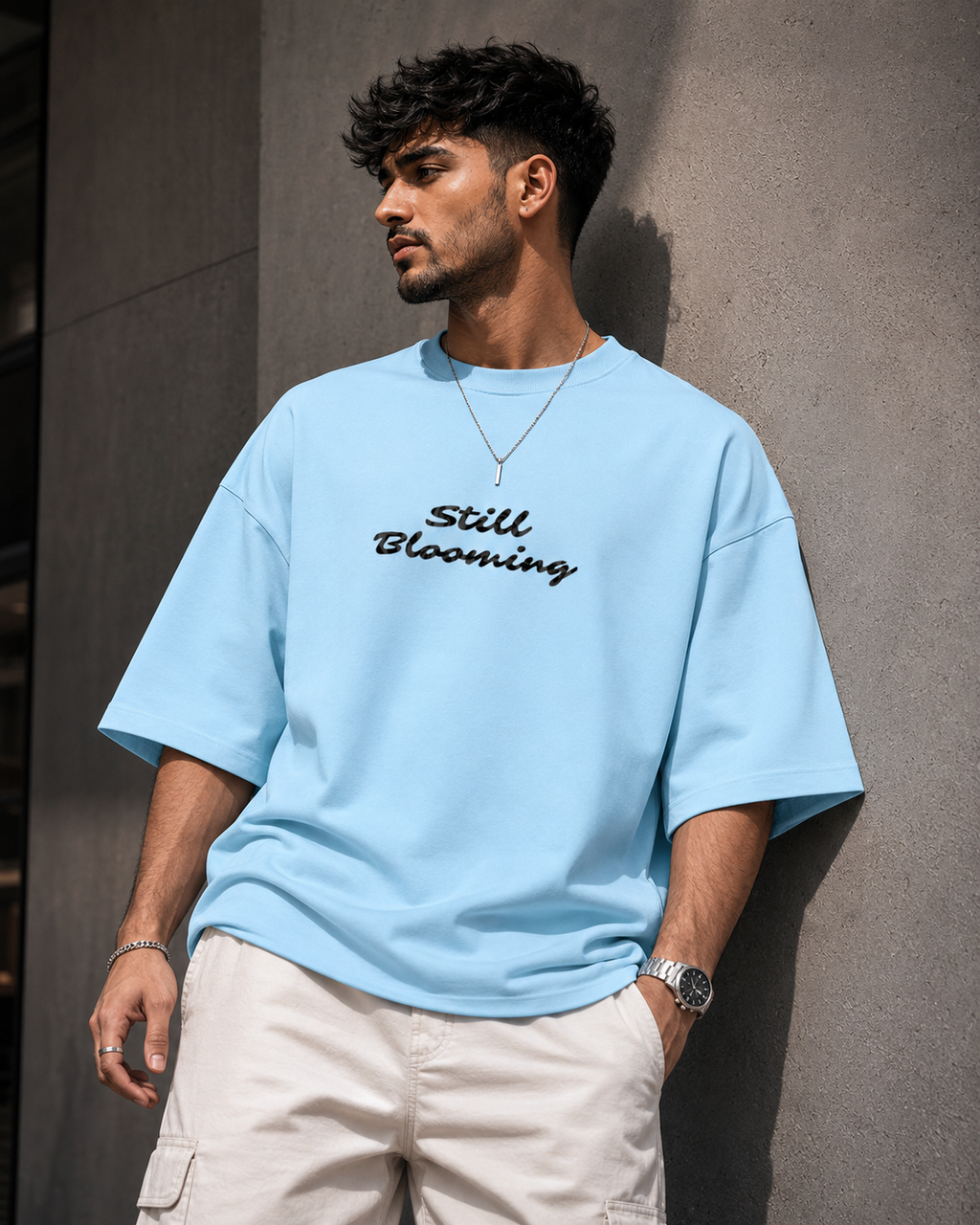 Baby-Blue Still Blooming Premium Oversized T-Shirt front view with Still Blooming typography graphic